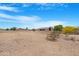View of the empty lot with desert landscaping and blue skies beyond the house at 19622 W Pasadena Ave, Litchfield Park, AZ 85340