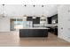 A modern kitchen featuring stainless steel appliances and an island with a granite countertop at 19622 W Pasadena Ave, Litchfield Park, AZ 85340
