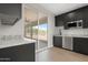 Modern kitchen with stainless steel appliances, dark cabinets, and granite countertops at 19622 W Pasadena Ave, Litchfield Park, AZ 85340
