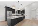 A modern kitchen featuring stainless steel appliances and an island with a granite countertop at 19622 W Pasadena Ave, Litchfield Park, AZ 85340