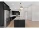 Well-appointed kitchen with stainless steel appliances, sleek dark cabinets, and granite countertops on a spacious center island at 19622 W Pasadena Ave, Litchfield Park, AZ 85340