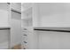 Well-organized walk-in closet with custom shelving and drawers for storage at 19622 W Pasadena Ave, Litchfield Park, AZ 85340