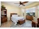 Cozy bedroom with a wooden bed frame, dresser, side table, ceiling fan and ample natural light at 20140 N 269Th Dr, Buckeye, AZ 85396