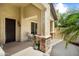 Welcoming covered porch with stone accents, seating area, security door and lush greenery at 20140 N 269Th Dr, Buckeye, AZ 85396