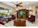 Elegant living room featuring custom built-ins, a ceiling fan, and comfortable seating arrangement at 20140 N 269Th Dr, Buckeye, AZ 85396