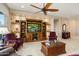 Elegant living room featuring custom built-ins, a ceiling fan, and comfortable seating arrangement at 20140 N 269Th Dr, Buckeye, AZ 85396