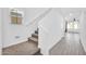 Hallway with stairs, white walls, carpeted stairs, and tiled floor that leads to other rooms at 20808 W Granada Rd, Buckeye, AZ 85396