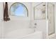 Well-lit bathroom with a separate shower and a tub under an arched window at 2236 E Rawhide St, Gilbert, AZ 85296