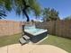 Backyard boasts a relaxing hot tub with easy step access, set in a private, walled patio with artificial grass at 2236 E Rawhide St, Gilbert, AZ 85296