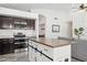 Kitchen showcasing an island, dark cabinetry, granite countertops, and stainless steel appliances at 2236 E Rawhide St, Gilbert, AZ 85296