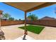 This cozy backyard features a small, well-kept artificial grass area and a covered patio at 22745 W Cocopah St, Buckeye, AZ 85326