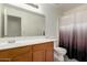 Bathroom with wood cabinets, white countertops, and combination shower and tub at 22745 W Cocopah St, Buckeye, AZ 85326