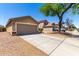 A tan two-car garage attached home with a long driveway and well-manicured landscaping at 22745 W Cocopah St, Buckeye, AZ 85326
