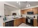 Functional kitchen featuring wooden cabinets, stainless steel appliances, tile floors, and a convenient breakfast bar at 22745 W Cocopah St, Buckeye, AZ 85326