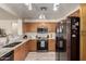 Well-equipped kitchen with wooden cabinets, stainless steel appliances, tile floors, and ample counter space at 22745 W Cocopah St, Buckeye, AZ 85326