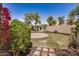 Inviting backyard with mature trees, colorful flowers, and a decorative playhouse at 2727 S 160Th Ln, Goodyear, AZ 85338