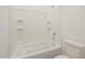 A full bathroom featuring a tub with white tiles and shelving niches at 28917 N 66Th Ave, Phoenix, AZ 85083