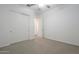 An empty bedroom with a ceiling fan, neutral carpet, and a closet at 28917 N 66Th Ave, Phoenix, AZ 85083