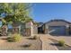 Beautiful single-Gathering home featuring a stone facade, mature tree, desert landscaping, and brick driveway at 28917 N 66Th Ave, Phoenix, AZ 85083