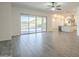 Bright living room featuring wood-look tile floors, sliding glass doors, and views of the backyard pool at 28917 N 66Th Ave, Phoenix, AZ 85083