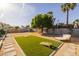 Spacious backyard featuring a lounge chair, artificial grass, and mature landscaping, perfect for outdoor relaxation and entertainment at 300 E Moore Ave, Gilbert, AZ 85234