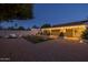 Expansive backyard featuring artificial turf cornhole area, lounge chairs, and ambient string lights at 300 E Moore Ave, Gilbert, AZ 85234