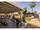 Beautiful backyard featuring a covered patio, string lights, built-in planters, and outdoor grill at 300 E Moore Ave, Gilbert, AZ 85234