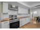 Kitchen showcasing stainless steel stove, hood, wood counters, and white cabinetry at 300 E Moore Ave, Gilbert, AZ 85234