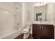 Bright bathroom featuring a tub-shower, wood-look tile, and vanity with storage at 30003 W Rockmount Ave, Buckeye, AZ 85396