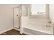Modern bath with tub and shower, tiled floors and large sunlit window at 30003 W Rockmount Ave, Buckeye, AZ 85396