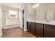 Bathroom featuring double sink vanity, wood-look tile flooring, and shower-tub combination at 30003 W Rockmount Ave, Buckeye, AZ 85396