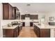 Spacious kitchen with granite countertops, wood floors, and dark cabinetry at 30003 W Rockmount Ave, Buckeye, AZ 85396
