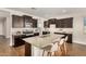 Modern kitchen featuring a large island with bar seating, stainless steel appliances, and wood floors at 30003 W Rockmount Ave, Buckeye, AZ 85396
