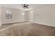 Bright living room featuring neutral paint, plush carpeting, and a ceiling fan for comfort at 30003 W Rockmount Ave, Buckeye, AZ 85396