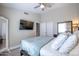 Bedroom with a ceiling fan, wood-look floors, and a wall-mounted TV at 3070 N 148Th Dr, Goodyear, AZ 85395