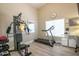 Well-lit home gym featuring a multi-station exercise machine, treadmill, and mirrored wall accents at 3070 N 148Th Dr, Goodyear, AZ 85395