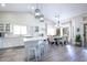 Bright, modern kitchen with white cabinetry, island seating, and an adjacent dining area at 3070 N 148Th Dr, Goodyear, AZ 85395