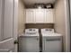 Neat laundry room with white cabinets, modern washer and dryer units, and organized storage at 3070 N 148Th Dr, Goodyear, AZ 85395