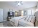 Bright primary bedroom with a ceiling fan, TV, ensuite bathroom and sliding glass door leading to exterior at 3070 N 148Th Dr, Goodyear, AZ 85395