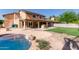 Backyard with a pool, outdoor kitchen, covered patio, and well-manicured lawn at 3203 E Ellis St, Mesa, AZ 85213