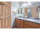 Bathroom features double sink vanity with granite countertops, wood cabinetry, and decorative mirrors at 3203 E Ellis St, Mesa, AZ 85213