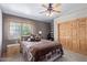 Comfortable bedroom with ceiling fan, closet, and bedside table with lamp at 3203 E Ellis St, Mesa, AZ 85213