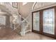 Grand foyer with elegant staircase, tiled floors, and a decorative front door with glass accents at 3203 E Ellis St, Mesa, AZ 85213