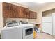 Functional laundry room features a sink, full-size washer and dryer, and overhead cabinets at 3203 E Ellis St, Mesa, AZ 85213
