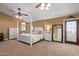 Large main bedroom with a four-poster bed, ceiling fan, and ensuite bathroom at 3203 E Ellis St, Mesa, AZ 85213