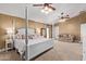 Spacious main bedroom with a four-poster bed, seating area, and carpet flooring at 3203 E Ellis St, Mesa, AZ 85213