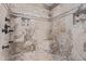Neutral stone shower with built-in seat and shower head and decorative stone inset at 3203 E Ellis St, Mesa, AZ 85213
