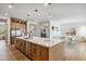 Open kitchen with an island featuring a stainless-steel dishwasher, and a view of dining and living spaces at 3366 E Constance Way, Phoenix, AZ 85042
