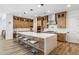 Spacious kitchen features a large island with seating, modern lighting, and wood-look tile flooring at 3366 E Constance Way, Phoenix, AZ 85042