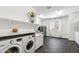 Well-lit laundry room with modern washer and dryer, countertop, and storage options at 3366 E Constance Way, Phoenix, AZ 85042